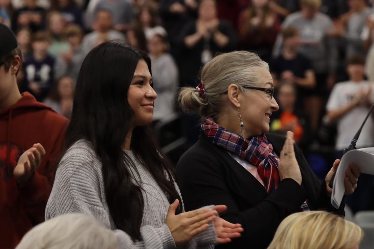 Junior Jackie Frame and her grandma, administrative assistant Suzanne Frame, clap along with the band at the end of the assembly. 