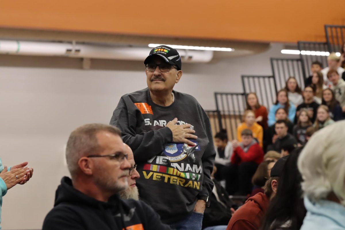 Air Force Veteran stands during his branch's song. 