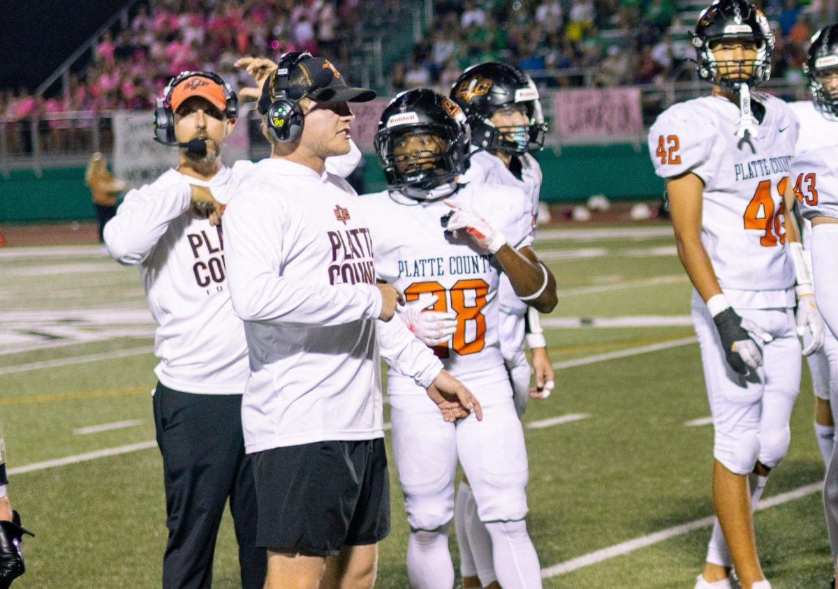 Senior DJ Smith, linebacker, receives instructions from coaches after a timeout vs. Smithville on Oct. 4, 2024.