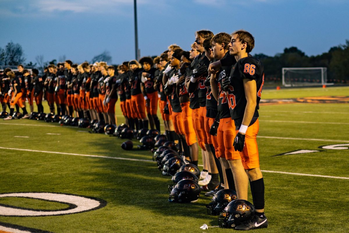 Football Players line up for the National Anthem