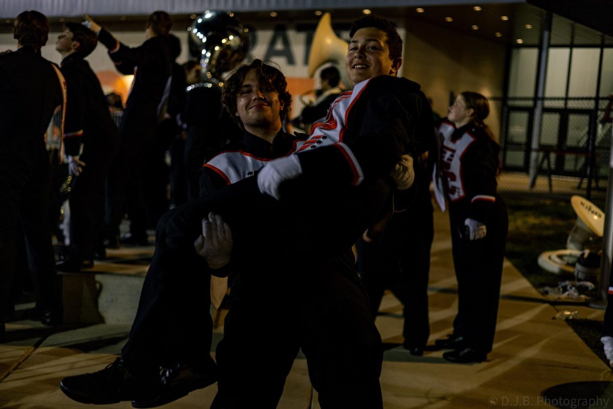 Junior Peter Tremain holds freshman Brennan Williams during the football game 