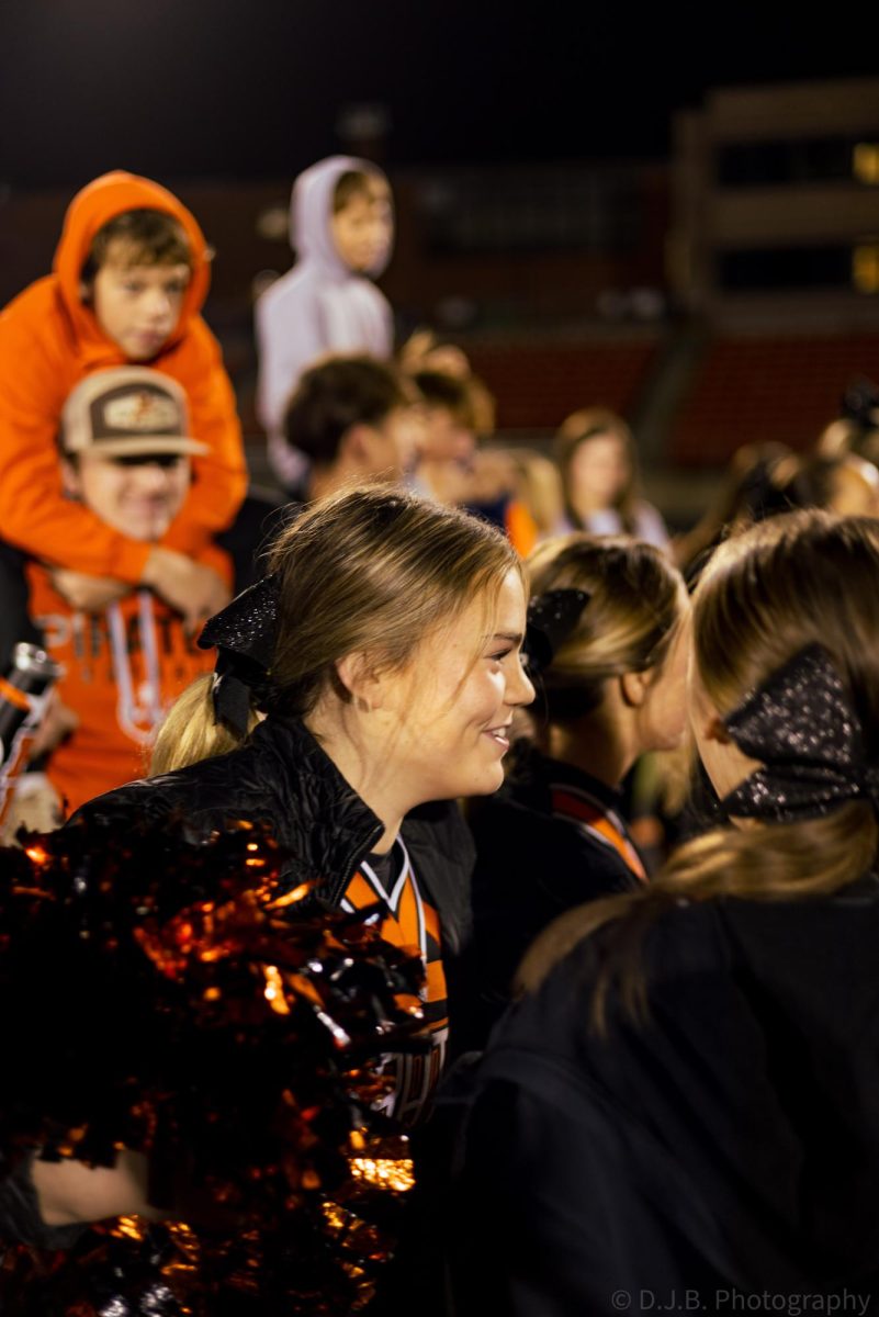 Cheerleader senior Caroline Ballou looks the cheer huddle .