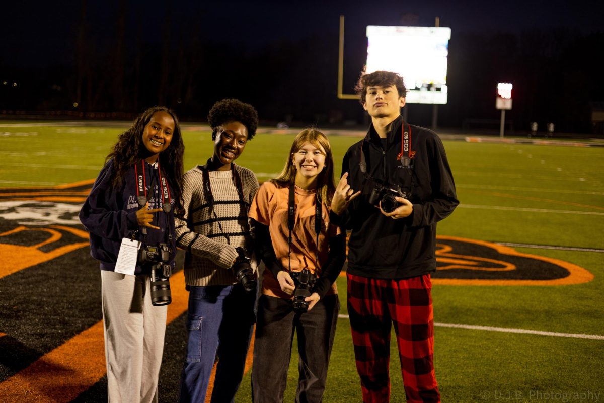 Yearbook photographers junior Gabriel Miller and sophomores Israa Elmi, Vanessa Sarpong, and Hailey Turner pose for a photo