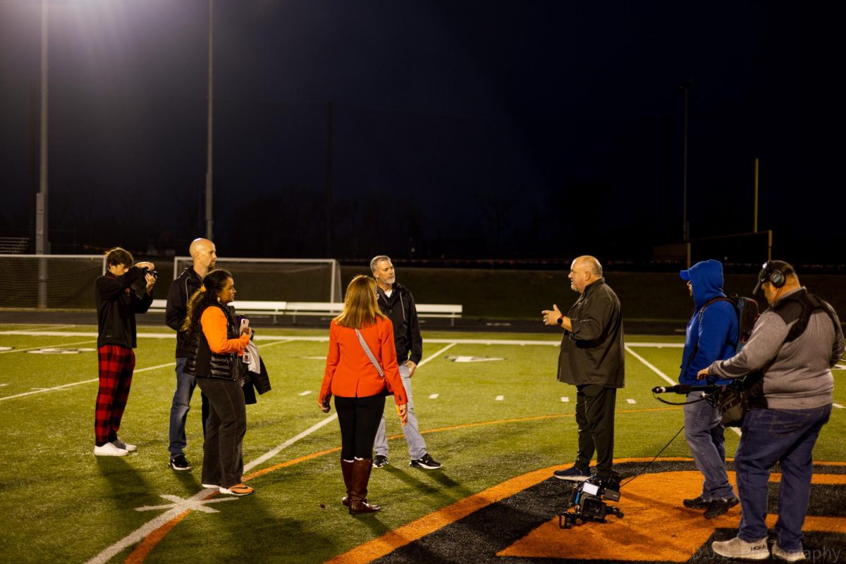 Administrators and teachers plan what will be done next for the TODAY Shows Friday morning lights segment while junior Gabriel Miller photographs the process 