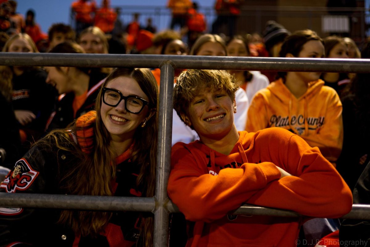 Senior Miranda Rhude and sophomore Keston Wimberly pose for a photo in the stands 