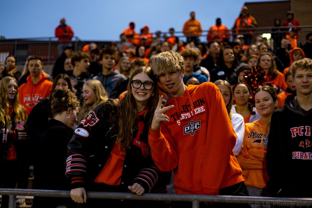 Senior Miranda Rhude and sophomore Keston Wimberly pose for a photo in the stands 