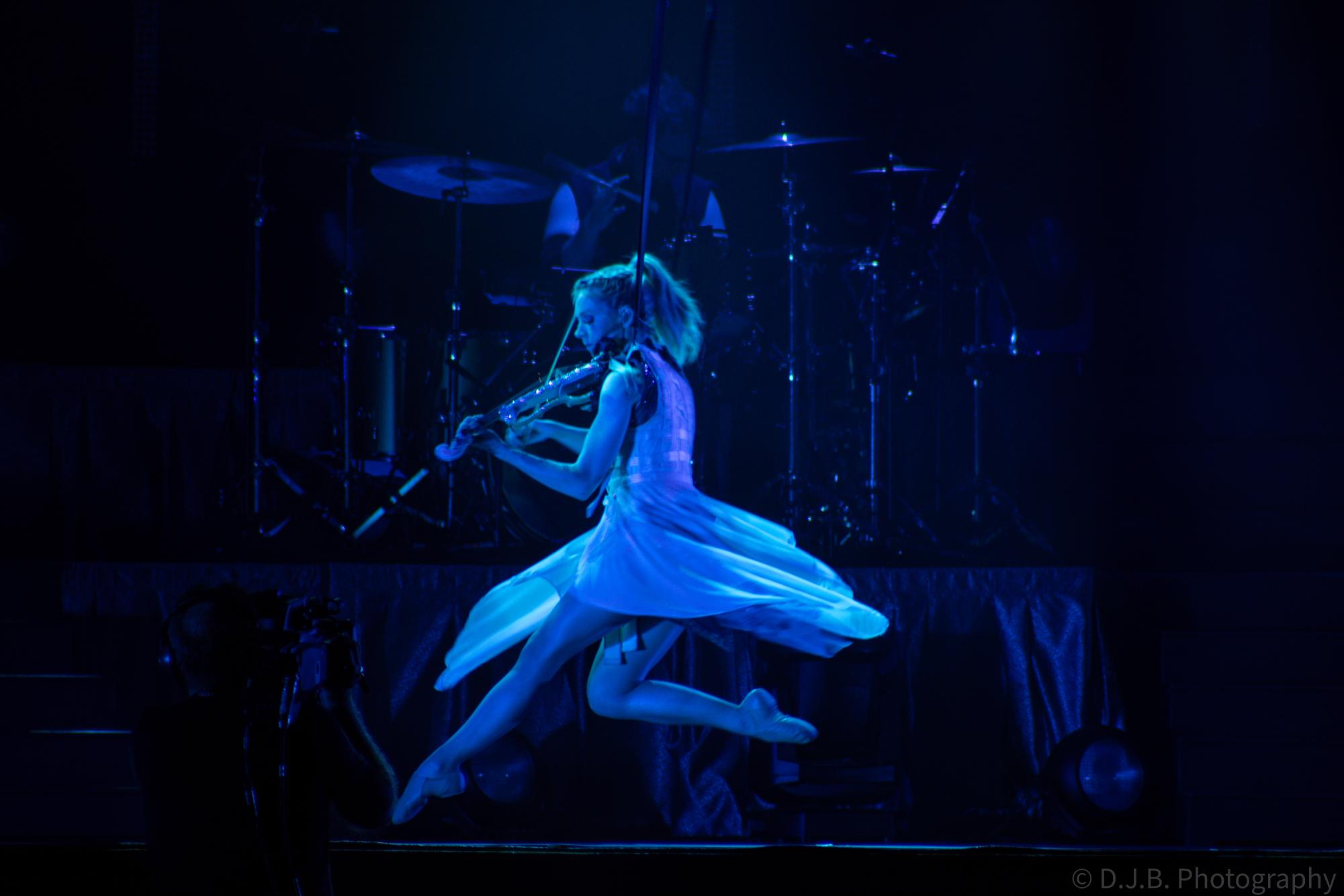 Lindsey Stirling hangs in the air playing violin at the Iowa state fair 