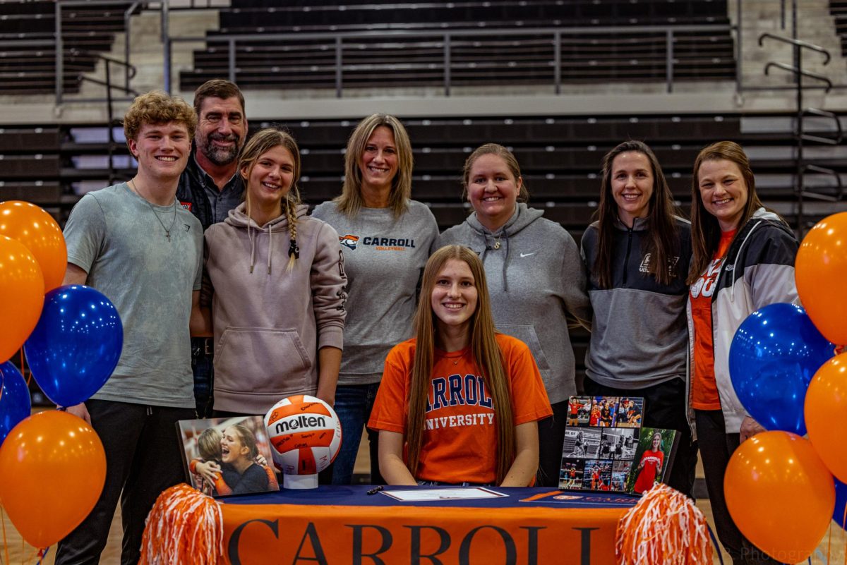 Surrounded by her friends and family Senior Karlee Riggs poses for photos to be taken of her for senior signing night to commemorate her being signed to Carroll University