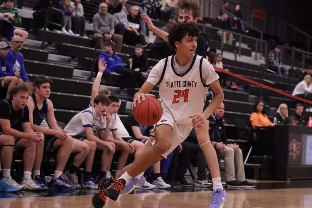 Carrying the ball to the post, senior Jaden Peterson competes at home against Grain Valley on Feb. 11. 