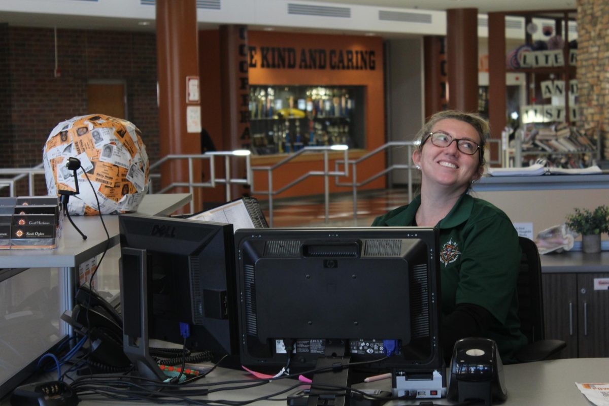 Laughing, Officer Andraya Kreiling sits at her desk at the welcome center.  