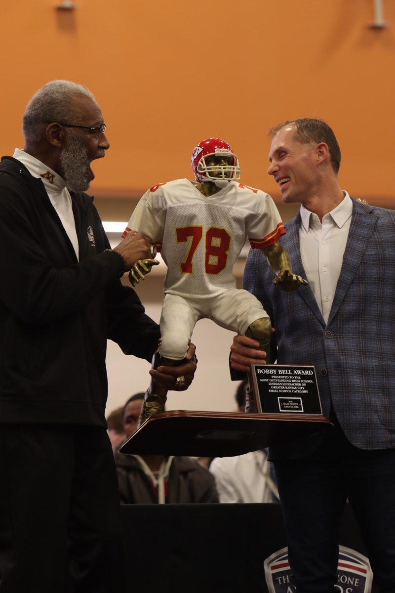 National Football Hall of Famer and Chiefs alumnus Bobby Bell presents the Bobby Bell award with former Bell award recipient and Platte County alumnus, Brain Koechner.