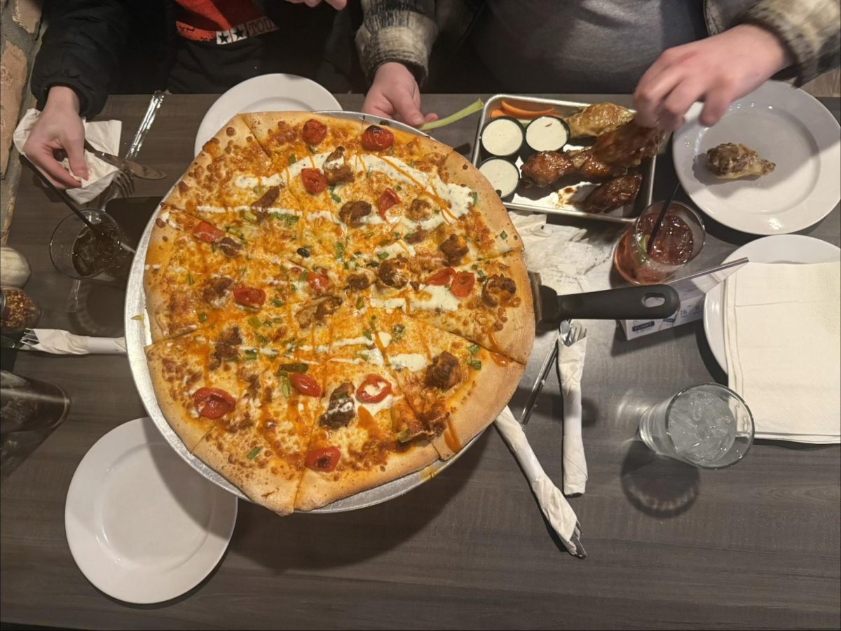 One of the main entrees served at The Cove is the "Buffalo Chicken Pizza", split into eight slices to share. 